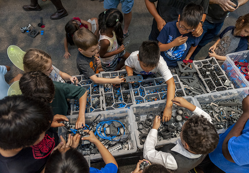 children looking over boxes of objects