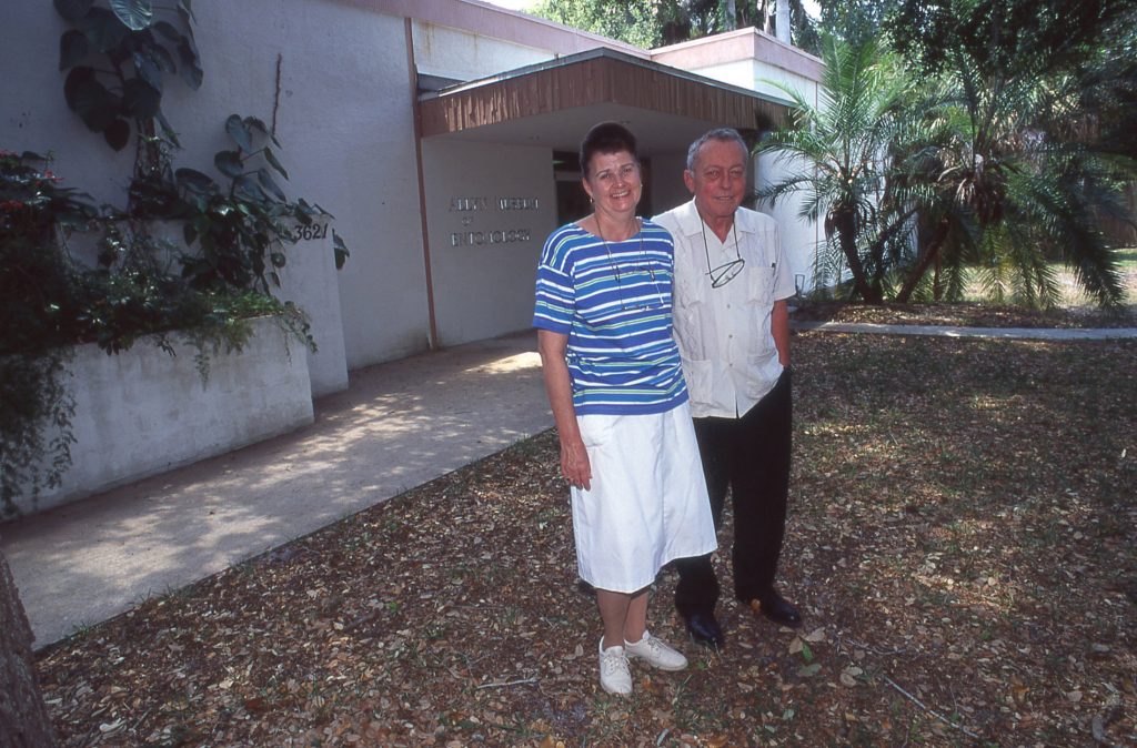 Two people stand in front of a building.