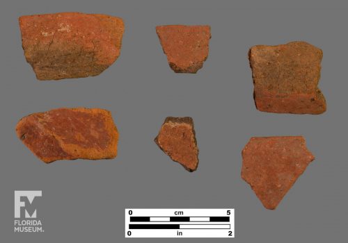 Formal artifact photo of six sherds, all of which are painted red.