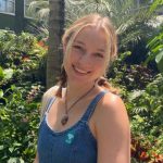 blond woman standing in front of greenery