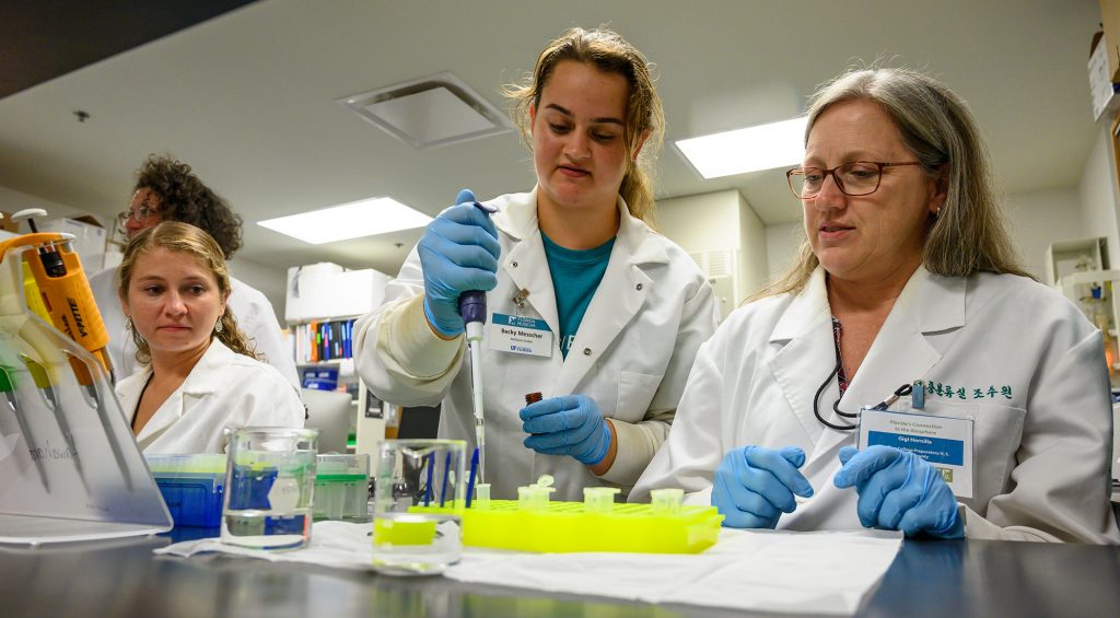 researching in white coats working with test tubes