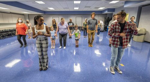 people dancing in room with blue floor