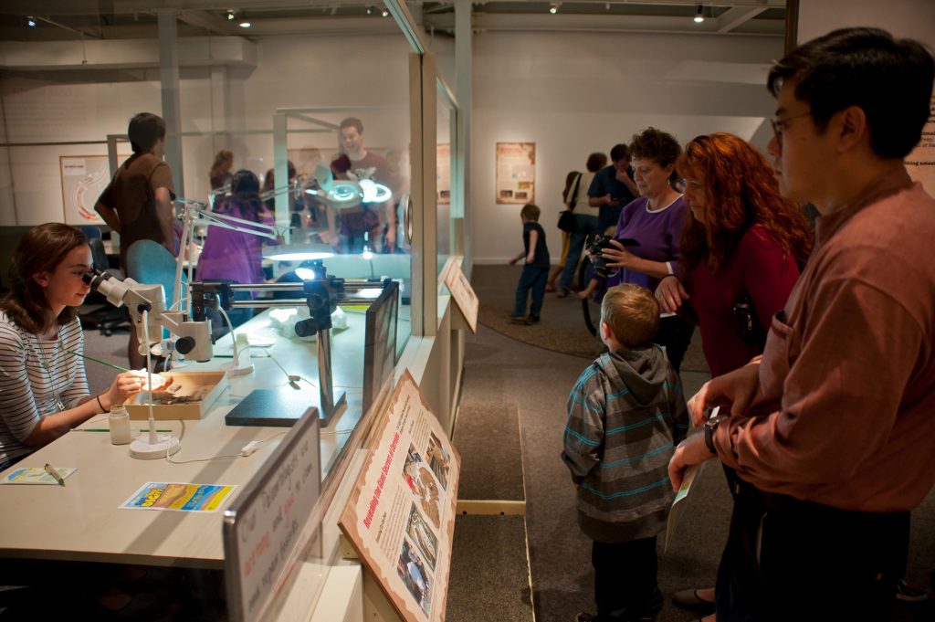 exhibit visitors want a researcher looking through a magnifier in the exhibits live lab