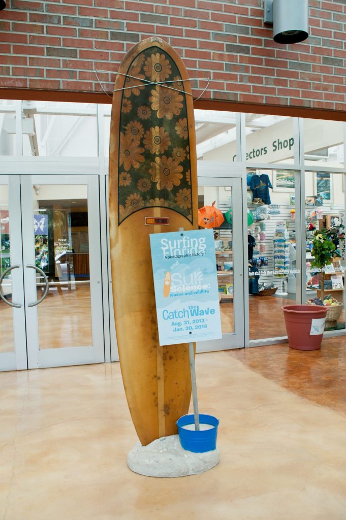 tall surf board on display in entrance of the museum