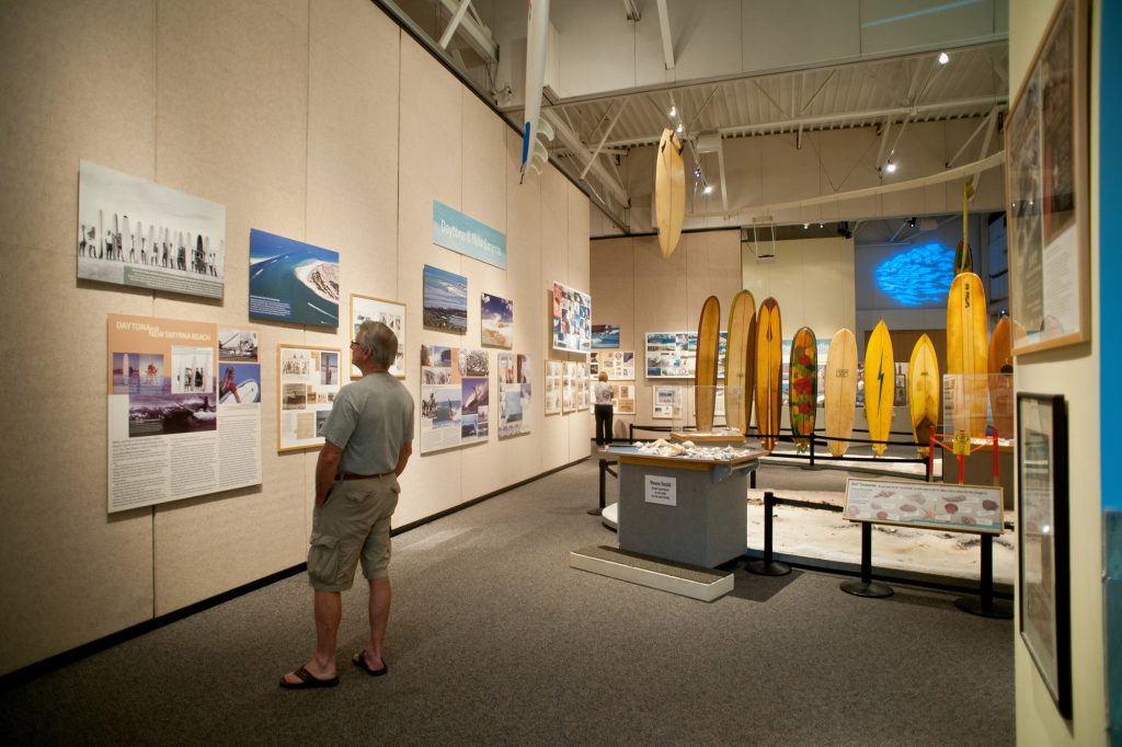 visitor reads displays hung on the wall at the surfing Florida exhibit