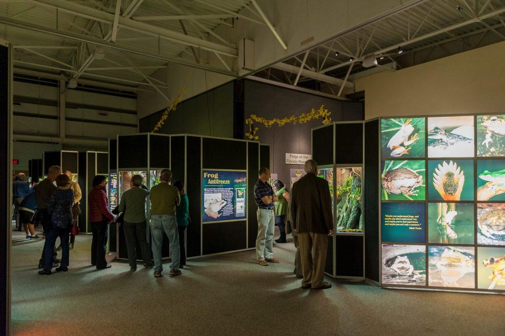 exhibit hall with people looking as display cases and signs