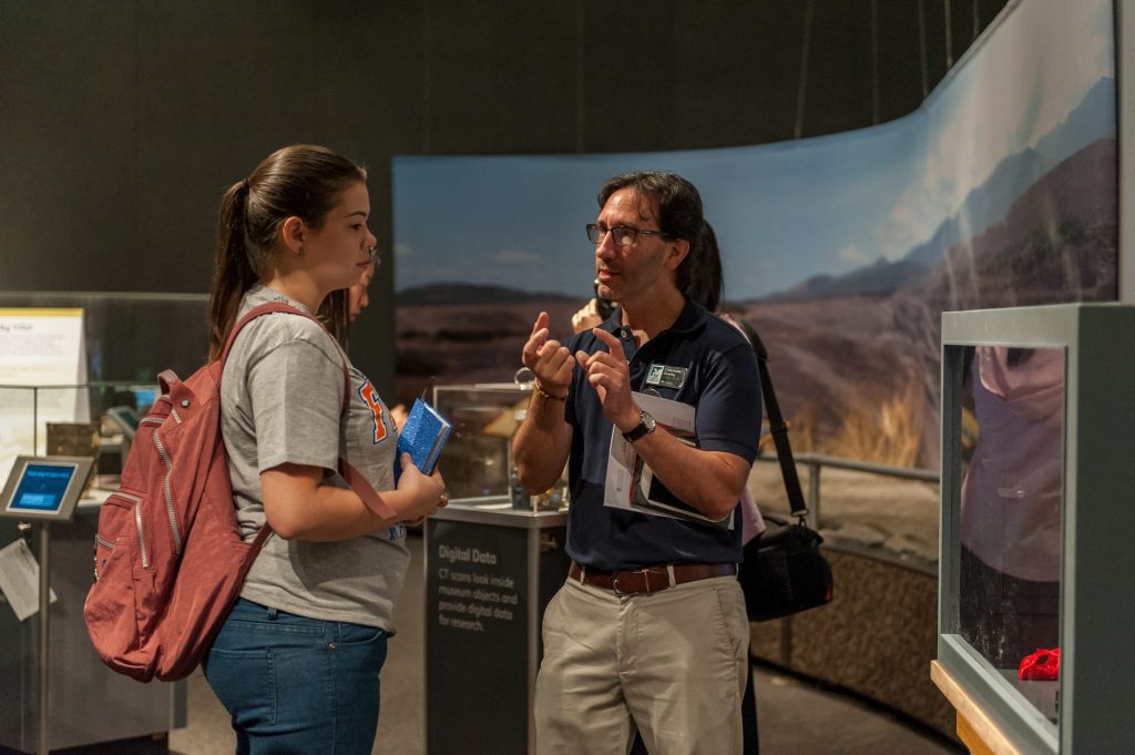 researcher and visitor speaking in the exhibit