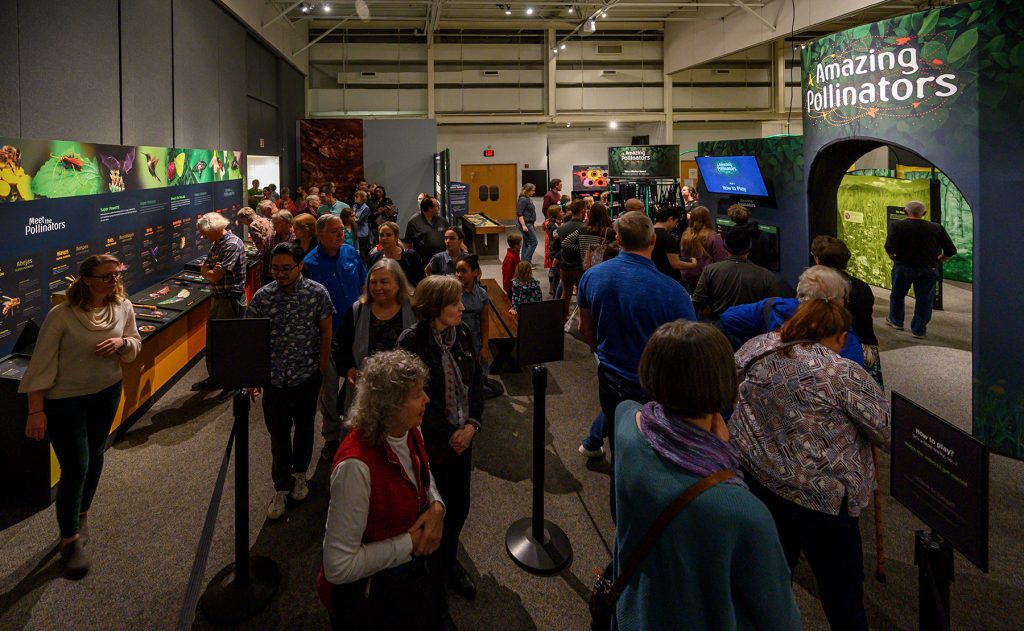 large crowd gathers in the amazing pollinator exhibit