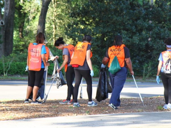 group of volunteers in orange vests picking up litter