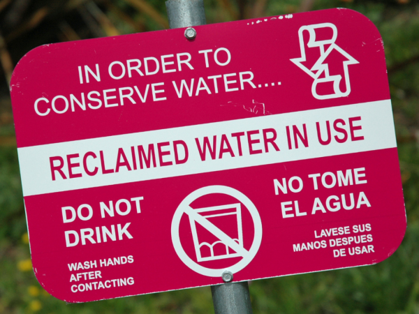 Red sign with text that reads: "reclaimed water in use. do not drink."