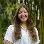 Kamila smiling in front of bamboo