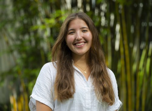 Kamila smiling in front of bamboo